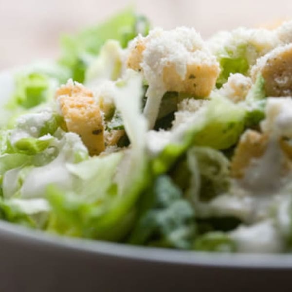 Close-up of a Caesar salad with crisp lettuce, croutons, and grated Parmesan cheese.